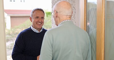 Alex speaking to someone at the door