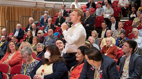 A member standing up to speak at conference