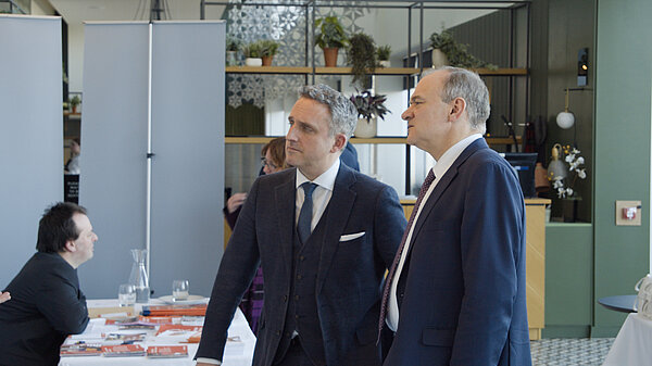 Ed Davey and Alex Cole-Hamilton at a Lib Dem conference exhibition stall stand